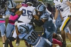 Shark defenders including, 4, Aydyn Cespedes and , 30, Aiden Orta converge on Land O, Lakes ball carrier , 25, Jaiden Gerena. Photo by JOE DiCRISTOFALO