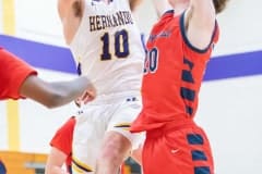 Hernando, 3, Josiah Wright extends to lift a shot past the defense by Springstead High, 4, Caidell Gilbert Tuesday 1/3/23 at Hernando High. Photo by JOE DiCRISTOFALO