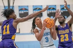 Nature Coast Tech, 3, Luke Sanders attempts to split the defense of Hernando High, 11, Aaron Laskey and, 23, Jesse Stewart Tuesday at NCT. Photo by JOE DiCRISTOFALO