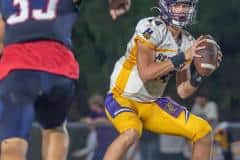 Hernando High QB Michael Saltsman sizes up the rush by Springstead High,33, Mykel Theriault in game at Booster Stadium in Spring Hill. Photo by Joe DiCristofalo.