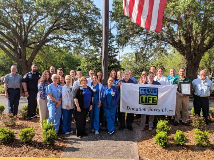 Oak Hill Hospital associates and attendees of the flag raising and prayer memorial service gather for a commemoration photo.