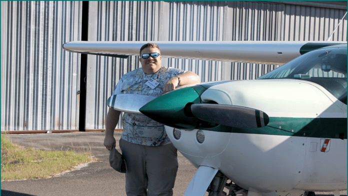James Chorvat stands next to his airplane.