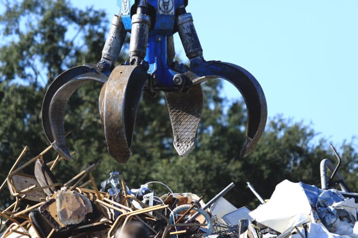 The grapple is used to clutch a group of chairs from a customers trailer to dump on the scrap pile that will later be collected by another recycling company where it will be shredded. 