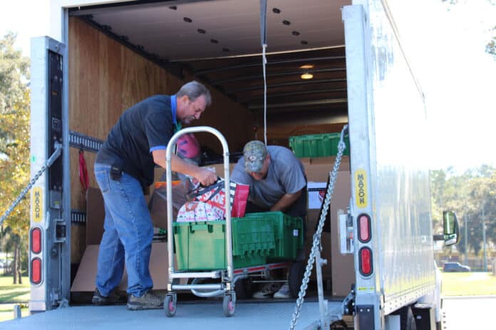 Merle Auvil (left) and Don Roberts (right) packing the truck that they will drive up to the Panhandle.