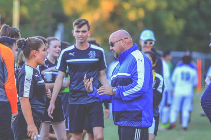 Coach Crawford talks to Alyssa Lechugga during a water break.