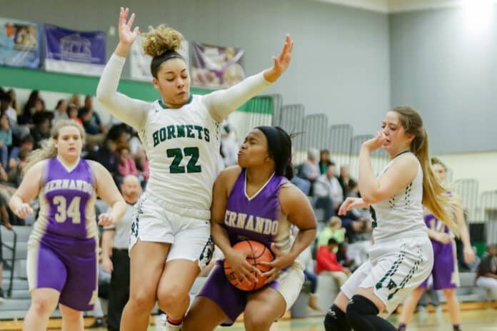 Weeki Wachee’s Seytia Hill (22) jumps to block Hernando Nakayla Roberts during her attempt for a field goal.