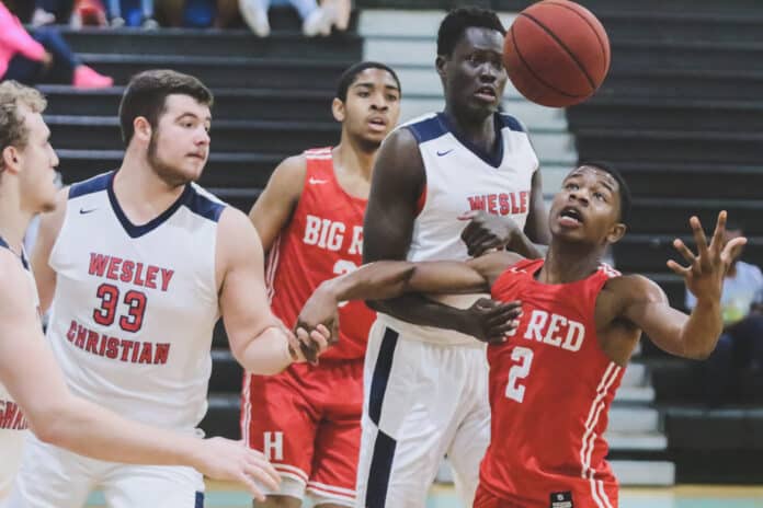 Hughes Senior AB Harouna attempts to retrieve the ball during the championship game against Wesley Christian 6’10” Senior Arol Kachoul. Photo by ALICE MARY HERDEN.