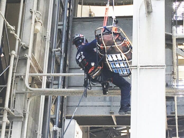 Firefighter trains at the CEMEX Brooksville plant silo. The firefighter has loaded a manequin into the rescue basket and then ziplines down a rope to an adjacent silo to complete the rescue.