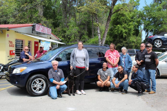 The Vans, Cars and Trucks crew with Tarah and her service dog Waylon in front of their new vehicle, courtesy of Vans, Cars and Trucks of Brooksville.