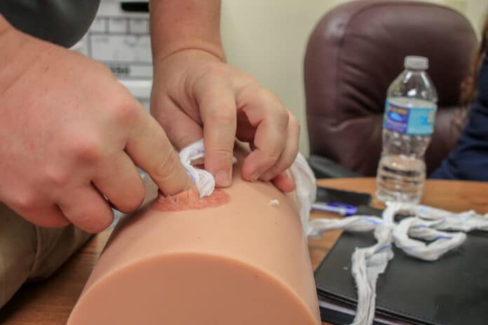 A participant at a recent class held on bleeding control learns how to pack 4 yards of Quikclot combat gauze into a wound to prevent further loss of blood.