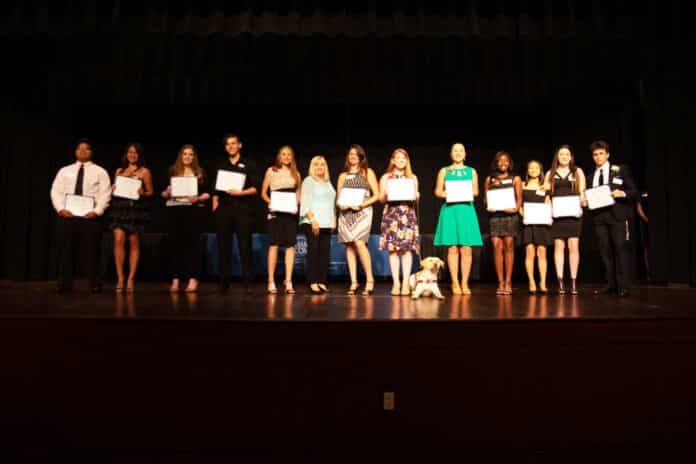 Students recognized in the academics category present their certificates.