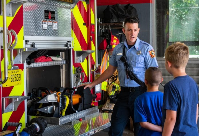 Firefighter Dakota Kastler talks about the jaws of life to two local children.