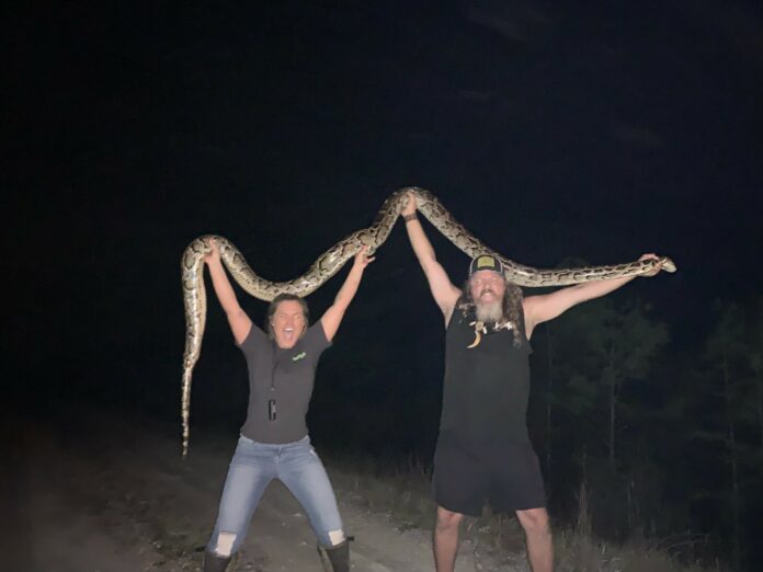 Miss Meghan Bailes with the one and only Wildman, Dusty Crum, with a 14’ female python newly removed from the Glades..