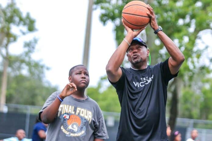Phillip Jones explains to a camper how to shoot the basketball. Phillip Jones and Marion Jones played basketball together at Hernando High School.