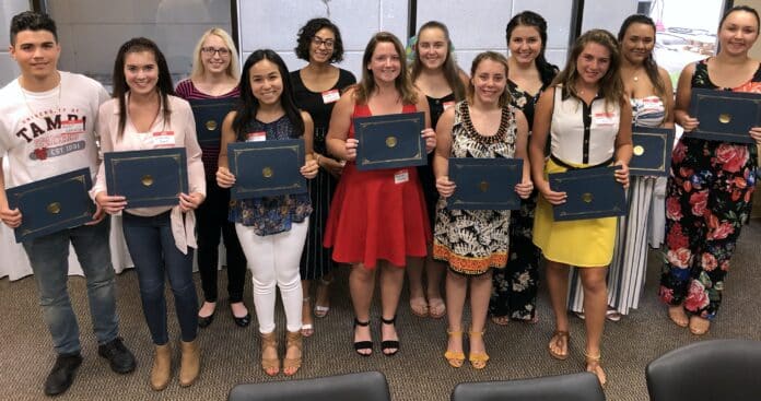 Volunteer Association scholarship recipients pose with their certificates recognizing their scholarships.