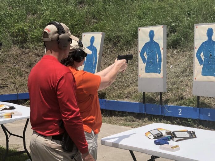 Instructor Ken Schneider shows Lisa MacNeil the basic  grip and stance. Photo by HCSO