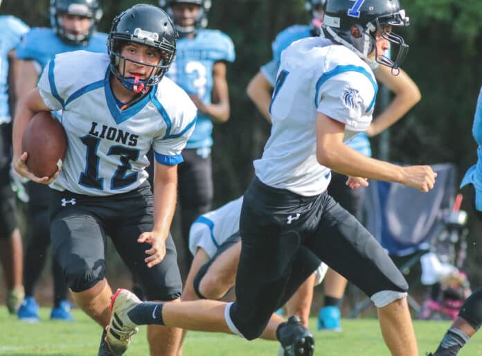 HCA Junior Zach Lechuga carries the ball to gain yardage for a first down during the game against Newberry Christian Community on Thursday night.