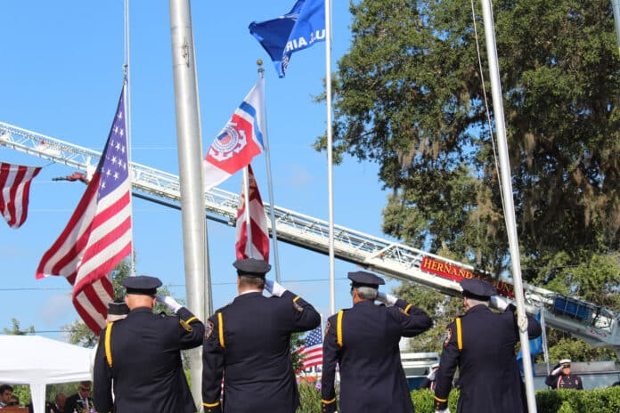 Color Guard salutes the flags as they are lowered to half staff in remembrance of Sept. 11, 2001