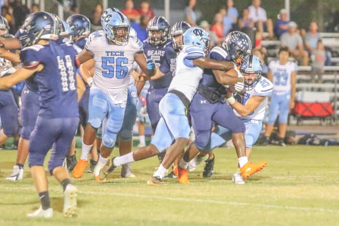 Bears’ Contae Cason attempts to gain yardage for Central as Shark defensive players Fabreyon Burnett (2) and Jaxson Morris (25) team up for a tackle.
