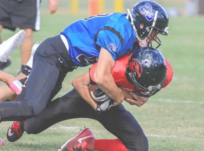 Lions’ Aiden Hopping tackles Village View player during the game Friday.