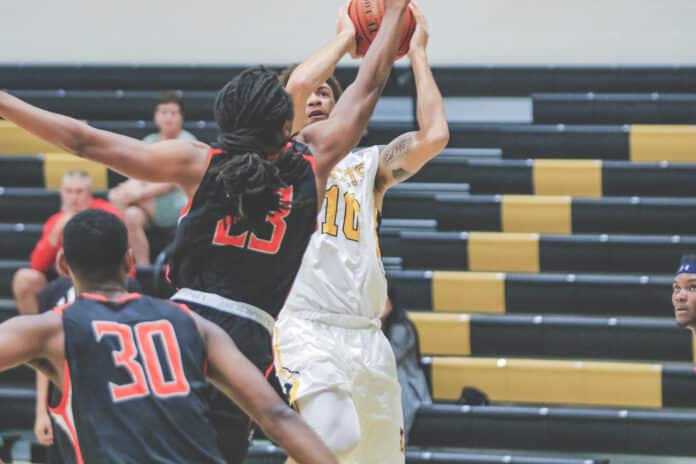 Daniel Buchanan-Derice attempts a 2 pointer as Johnson University player Jordan Battle attempts to block