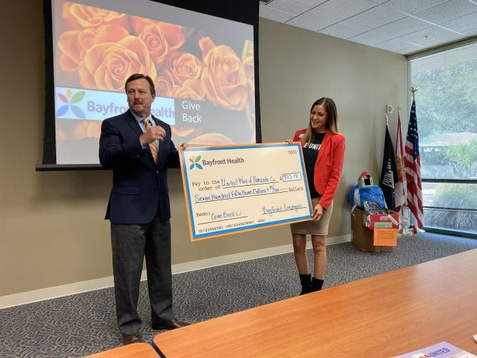 Ken Wicker CEO of Bayfront Health Brooksville presenting Angie Bonfardino-Walasek Director and CEO of United Way Hernando County with the proceeds of the ‘Bayfront Gives Back’ pretzel bite fundraiser. 