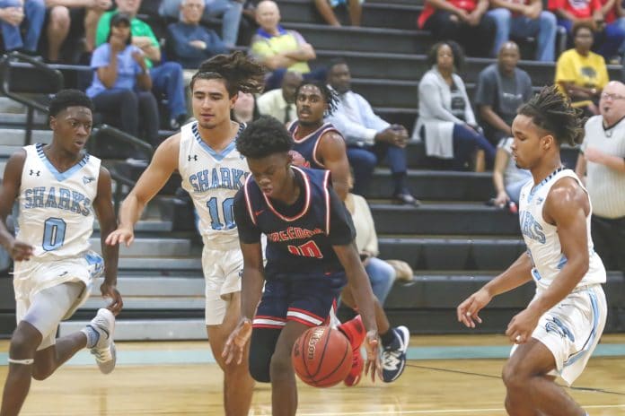 Freedom’s Josh Germain II (10) dribbles down court as Sharks’ Malek Harris (0), Anthony Trepen (10), and Dedric Hall attempt to get in position for court defense.