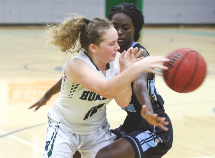 Hornets’ Alexis Holley (10) passes behind Sharks’ Amimah Spellman (12)  during the Hornets’ home game against Nature Coast Tech Friday Night.