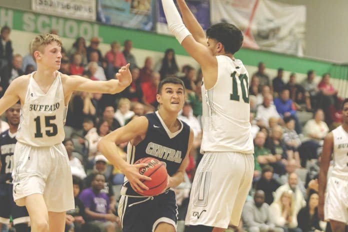 Sophomore Tre Joyner (2), pushes through The Villages Charter defense players, Diego Romero (10) and Samuel Walters (15) during the boys district final game on Feb. 14.  File Photo by Alice Mary Herden.