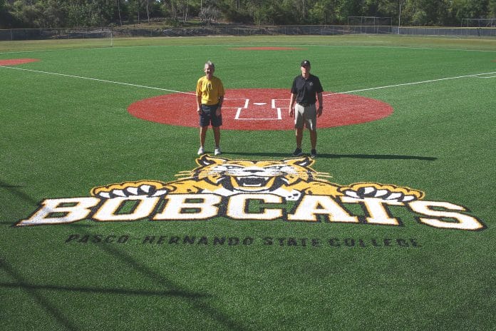 Pasco Hernando State College Athletic Director Steve Winterling and Baseball Coach Lyndon Coleman standing at home plate with the new PHSC Bobcat logo that was included in the field renovations.