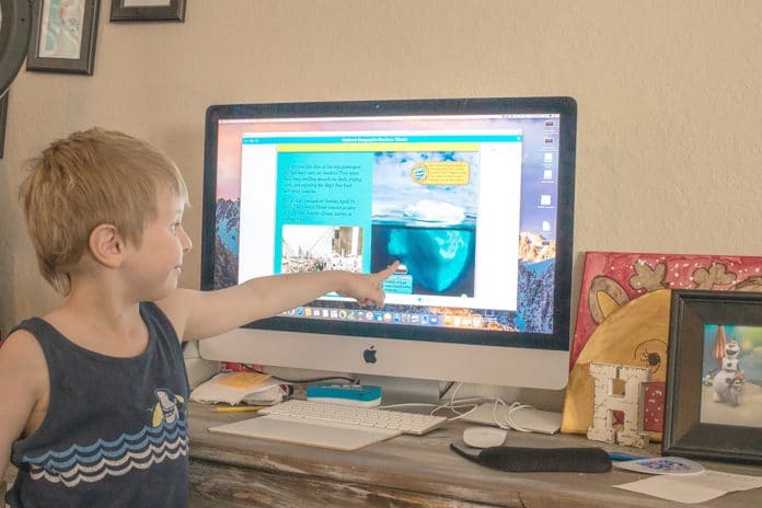 Weston Hebson is a first-grader at Hernando Christian Academy. He continues his education at home with his teacher via Zoom during the stay-at-home order.  Weston is working on his reading assignment.  Photo by Betty Kolar.