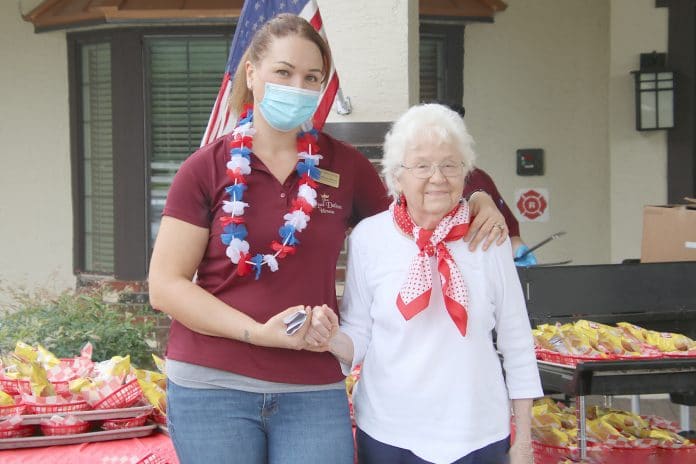 Life Enrichment Director, Alyson Truong is with resident Helen McNabb during the Patriotic Picnic Parade for Memorial Day at the Royal Dalton House