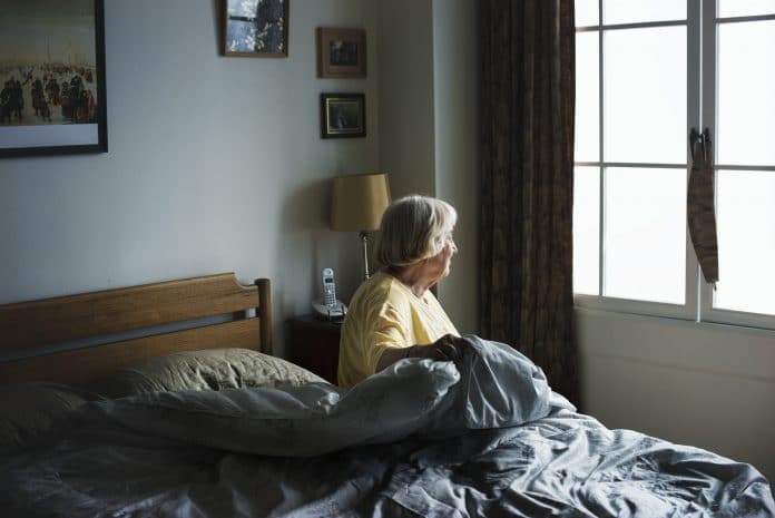 Stock photo of elderly woman looking out window