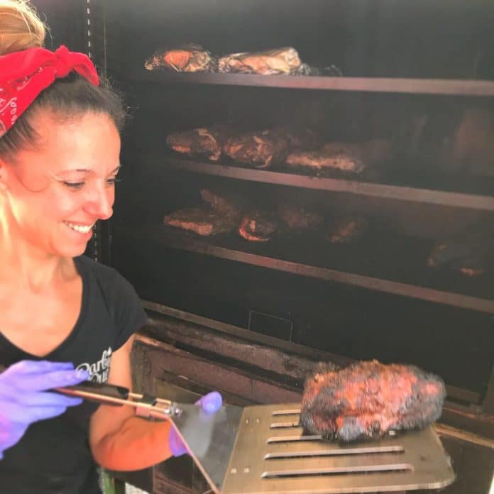 Laurie-Ann Wilkens checks on some barbeque cooking in her food truck.