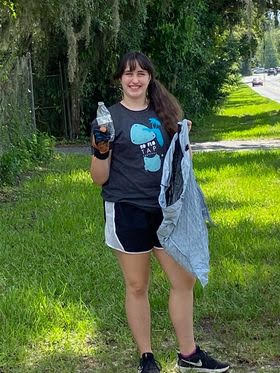 Emma Bolton collects trash to improve water quality.