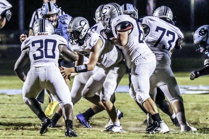 September 25, 2020 Friday night lights at Nature Coast High School. The Central Bears take on NCT Sharks. Sharks #15 So. Brady Nowlan eyes Bears. #7 QB Caleb Wood hands the ball off to Bears #30 Alec Robichaud.