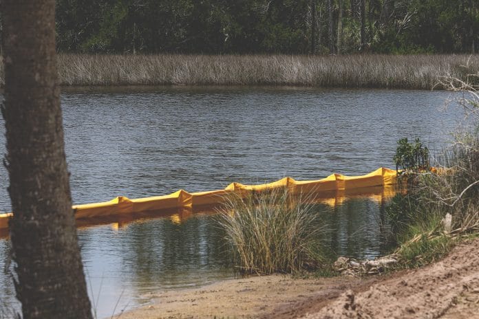 Another area off of Bayou Drive has a floating barrier assembled to help control debris from entering further into the salt marsh. - File photo by ALICE MARY HERDEN