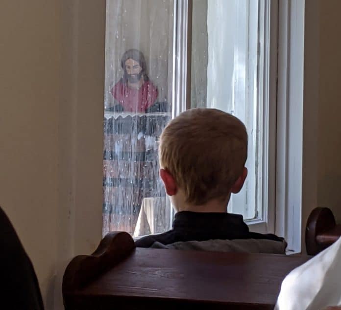 A young boy attends the All Souls Day service at St. Stanislaus Church in Brooksville, Nov. 2, 2020