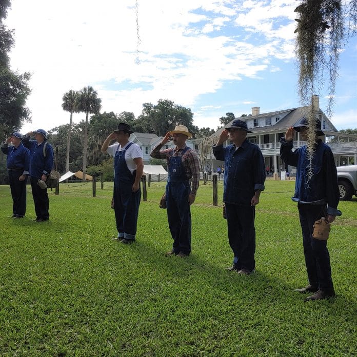 CCC re-enactors saluting the flag.