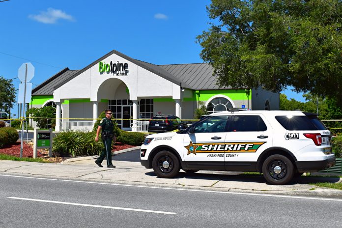 An unidentified deputy walks toward an HCSO vehicle outside the BioSpine Institute, the scene of the shooting