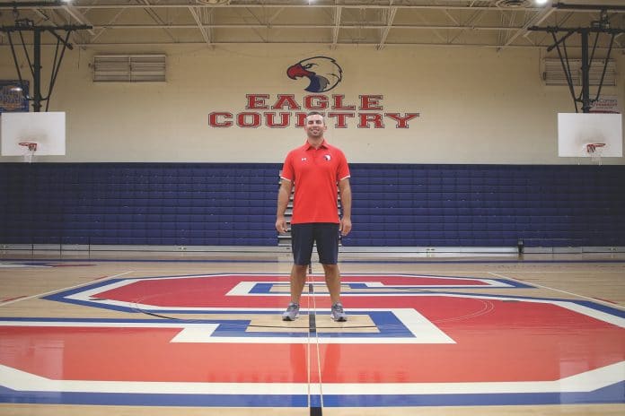 Springstead High AD Dustin Kupcik stands center court in the SHS gym. Over two years, the gym has seen some changes, from new lights to graphics. Photo by Alice Herden.