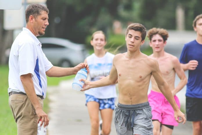 Hernando High’s Cross Country coach Travis Bruns waits for the Hernando High cross country runners during their practice run near Hernando High School on August 16. 