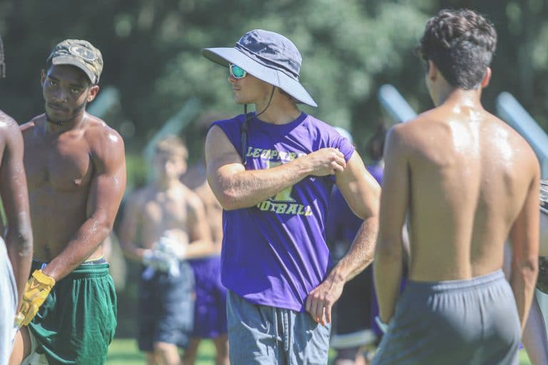 Bronson Tafelski looks across the field as the players get ready for another play during practice. “The main reason I am here is my nephew is playing, so I can get to be with him on the sidelines, which is a lot of fun to [share that] same energy,” Tafelski said. Photo by Alice Mary Herden