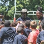 Robert Baker (left), Dante Mason, Tyrone Goodson, and Coach Maner (right) gather the campers together for a huddle after a break.