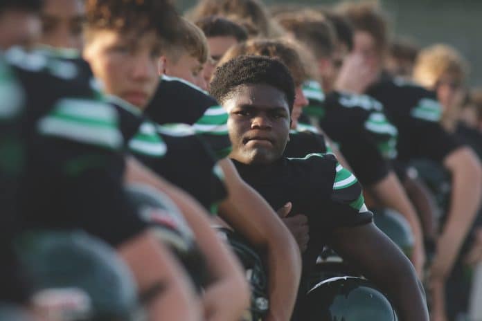 Weeki Wachee vs Sunlake: Hornet’s Sam Daniels stands with his teammates for the National Anthem before the preseason game against Sunlake on Friday night August 20 at Weeki Wachee High School. Photo by Alice Mary Herden