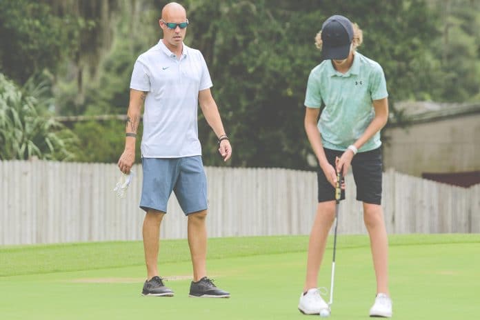  Leopards golf coach Kevin Bittinger watches his son and Leopards golfer Drew Bittinger attempt a put during their practice on August 16 at Brooksville Country Club in Brooksville.