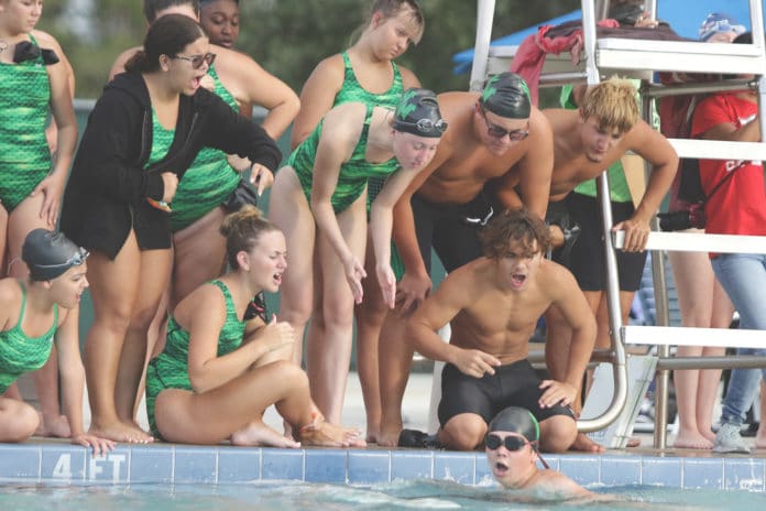 Swimmers from the Weeki Wachee swim team cheer on a fellow teammate during the swim meet against Springstead.