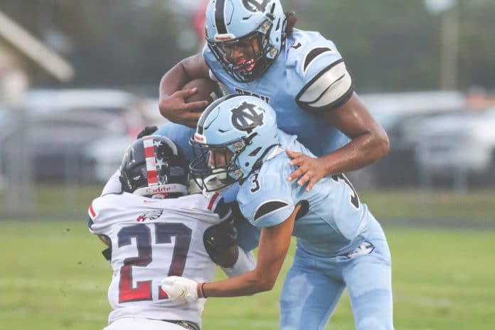 Sharks' Christian Cromer (2) jumps over Eagles Kevin Oakes as Sharks Carlos Rodriguez (3) attempts to block.