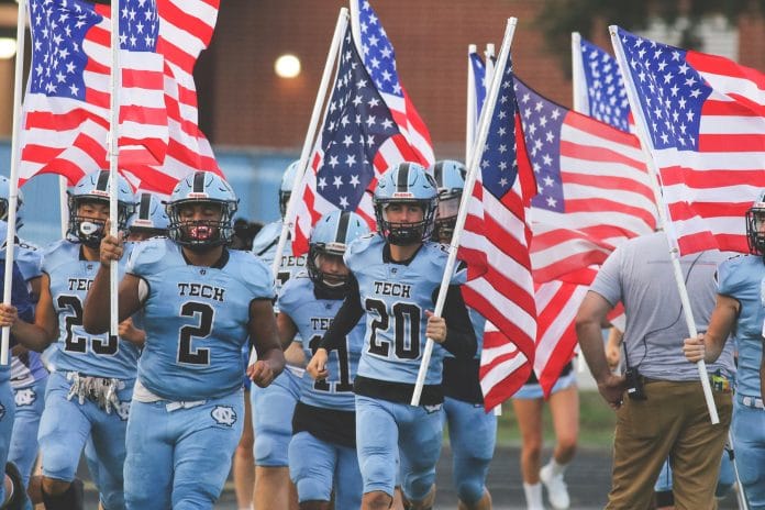 Sharks players come out of the Sharks helmet holding twelve flags at the start of the game. 