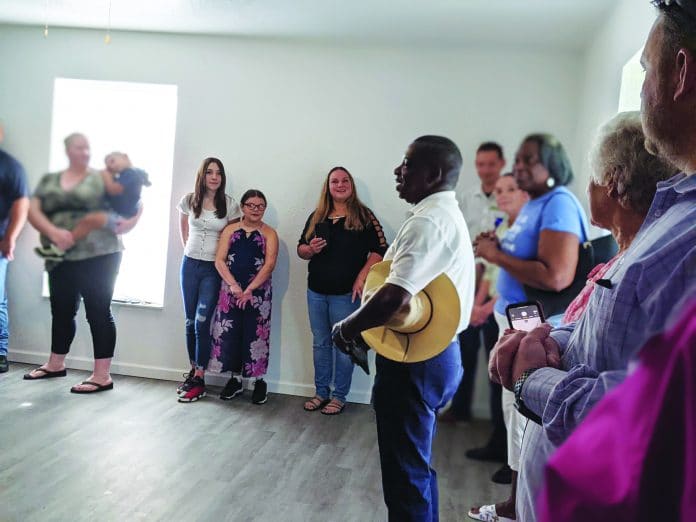 Pastor Malachi of Victorious Church of God by Faith blesses the White Family's new home.